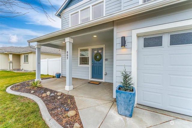 doorway to property featuring a porch and a garage