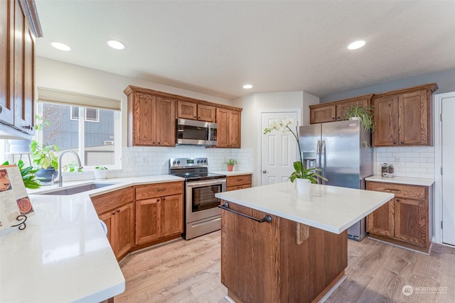 kitchen with a kitchen island, sink, appliances with stainless steel finishes, and tasteful backsplash