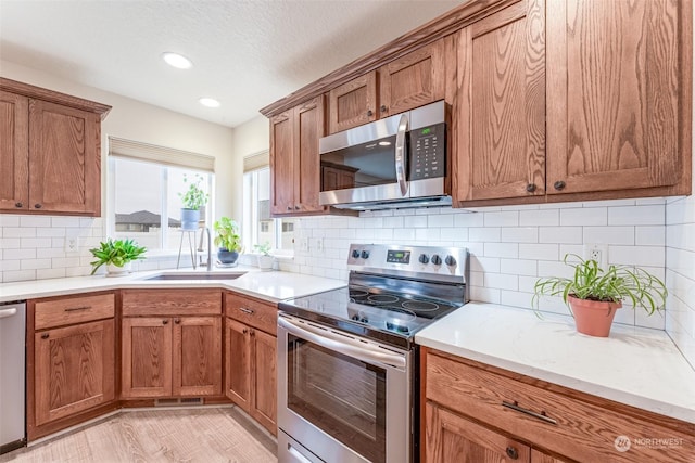 kitchen with backsplash, sink, and appliances with stainless steel finishes