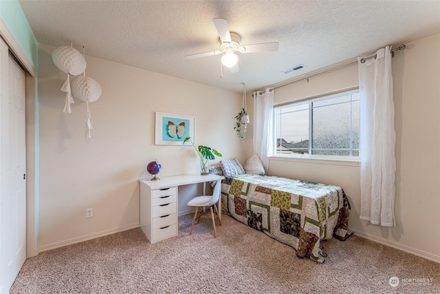 carpeted bedroom featuring ceiling fan, a textured ceiling, and a closet