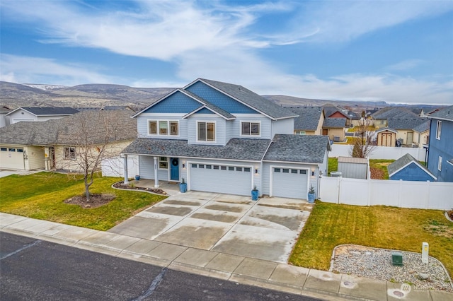 view of front of property featuring a mountain view, a front lawn, and a garage