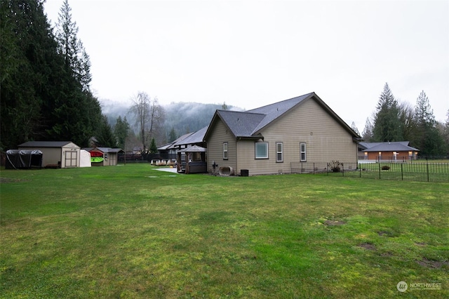 view of side of property with a lawn, a storage shed, and central air condition unit