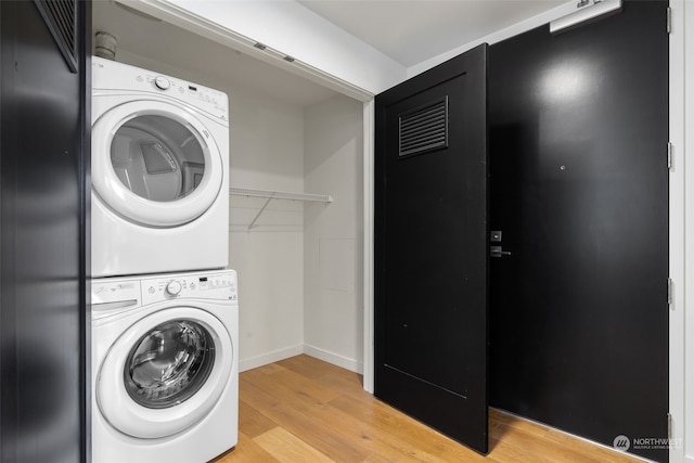 washroom featuring light hardwood / wood-style flooring and stacked washer and clothes dryer