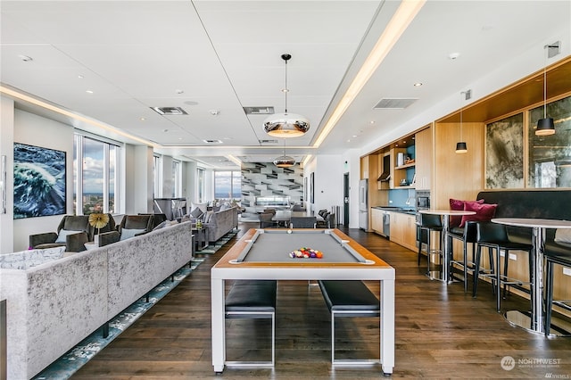 game room with billiards, a healthy amount of sunlight, a tray ceiling, and dark wood-type flooring