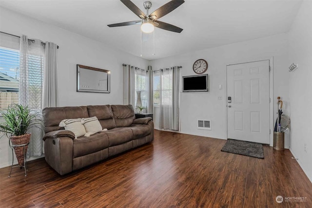 living room featuring dark wood-type flooring and ceiling fan