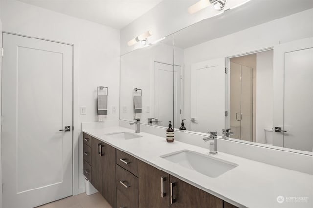 bathroom featuring a shower with door, vanity, and tile patterned floors