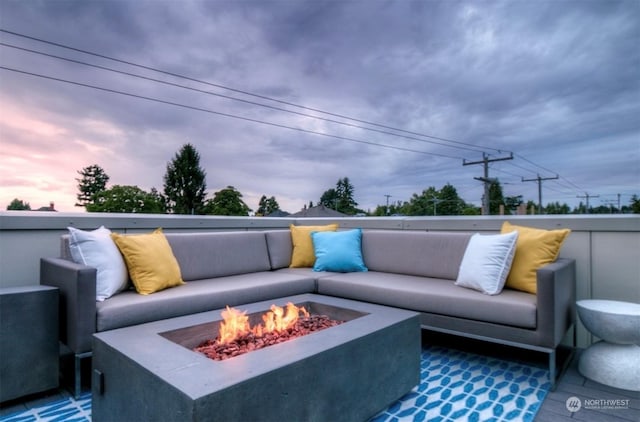 patio terrace at dusk with an outdoor living space with a fire pit