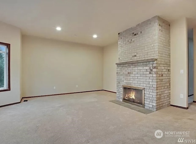 unfurnished living room with a fireplace and light colored carpet