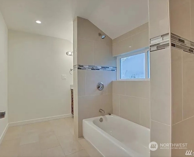 bathroom with tile patterned floors, tiled shower / bath combo, and lofted ceiling