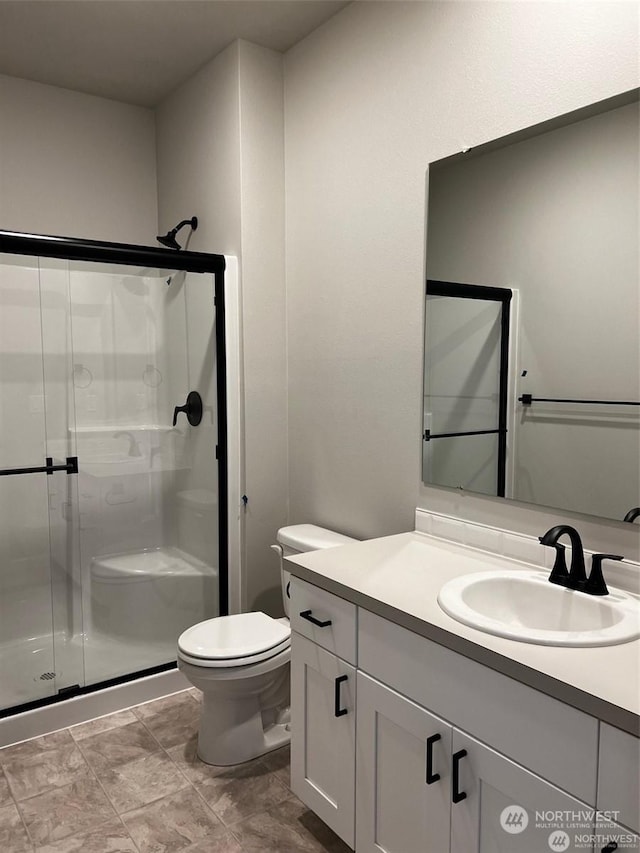 bathroom featuring vanity, toilet, and an enclosed shower