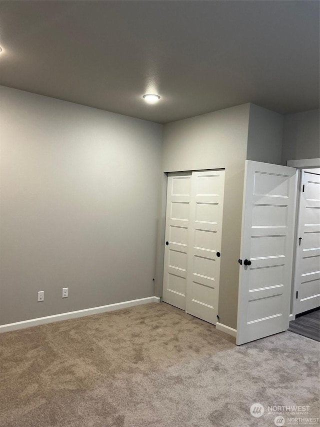 unfurnished bedroom with light carpet and a closet