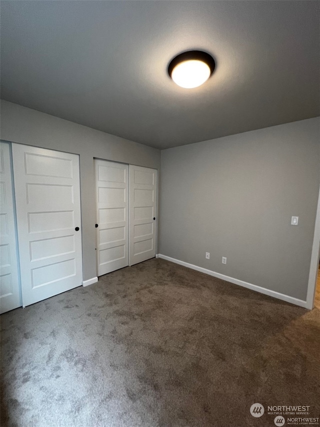 unfurnished bedroom with dark carpet