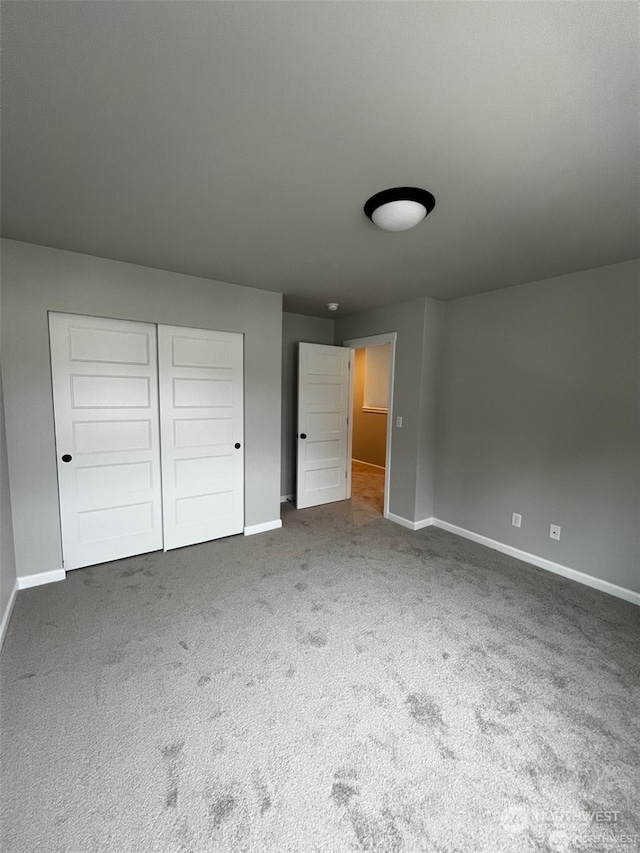 unfurnished bedroom featuring carpet flooring and a closet