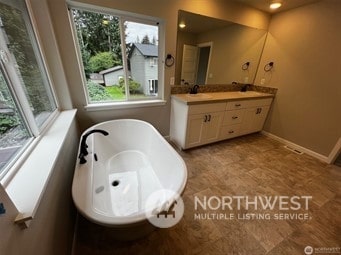 bathroom with vanity and a tub