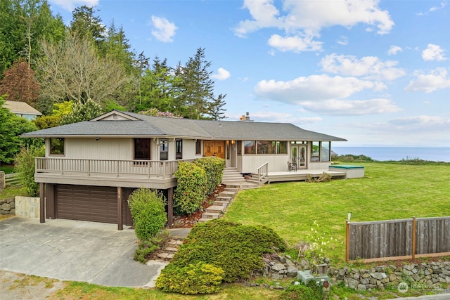 view of front of home with a wooden deck, a front yard, and a garage