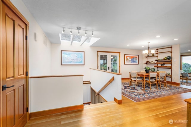 dining area with a skylight, plenty of natural light, and hardwood / wood-style floors