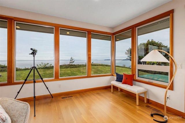 sunroom / solarium featuring a water view