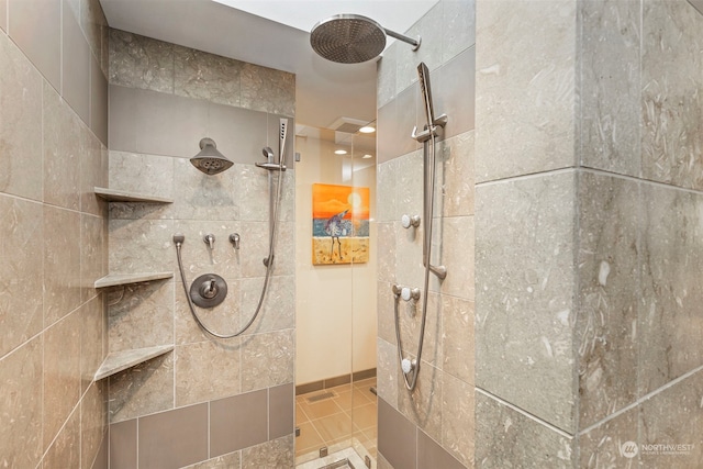 bathroom with a tile shower and tile patterned floors