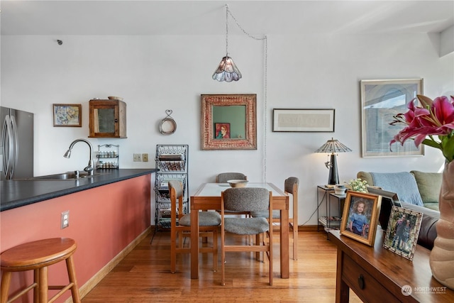 dining space with wood-type flooring and sink