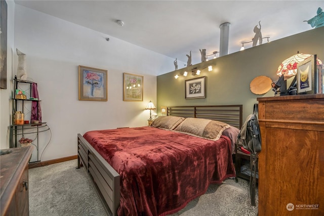 bedroom featuring vaulted ceiling and light colored carpet