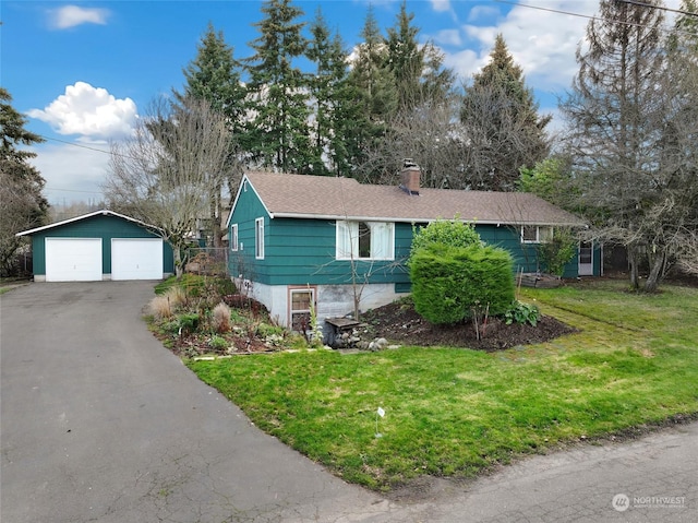 view of front of home with a front yard, a garage, and an outdoor structure