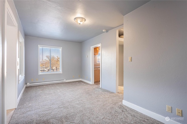 unfurnished bedroom with a baseboard radiator, ensuite bath, and light colored carpet