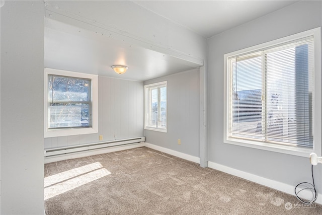 carpeted spare room featuring plenty of natural light and baseboard heating