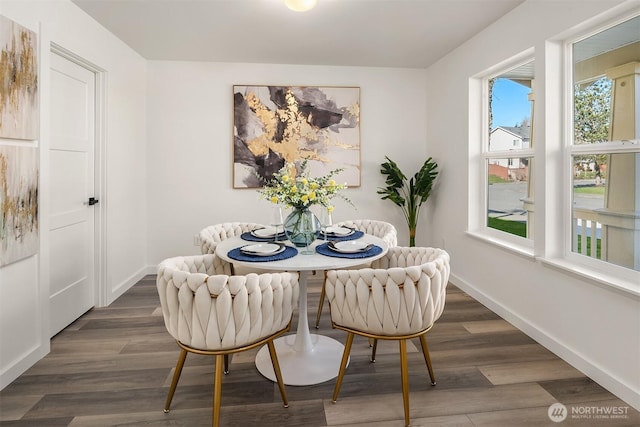 dining room featuring dark wood-style flooring and baseboards