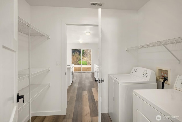 laundry area featuring laundry area, visible vents, baseboards, dark wood-style floors, and washing machine and dryer