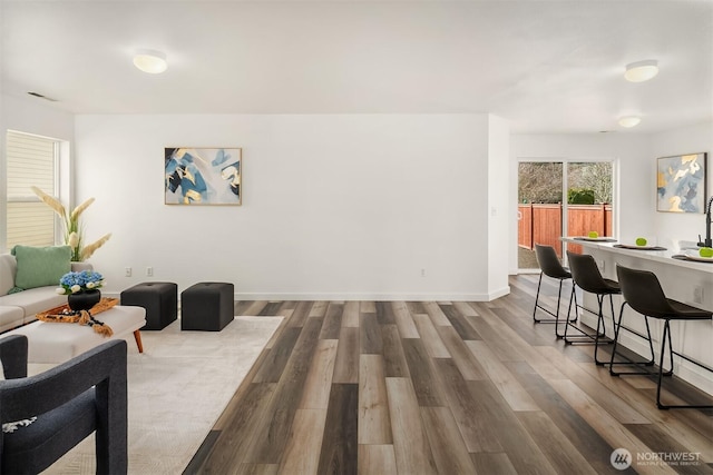 living area featuring baseboards and dark wood-style flooring