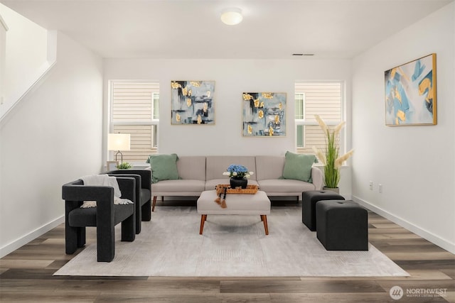 living area featuring visible vents, baseboards, and wood finished floors