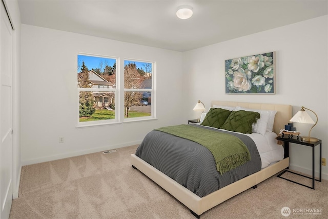 bedroom with carpet floors, baseboards, and visible vents