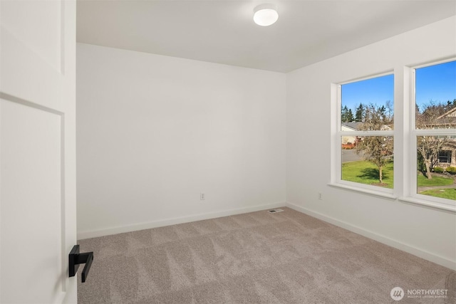 carpeted empty room with baseboards