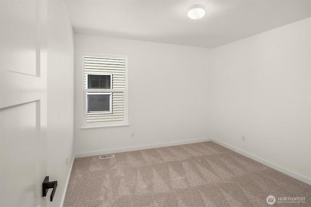 spare room featuring carpet, visible vents, and baseboards