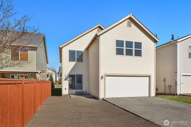 view of front facade with a garage and fence