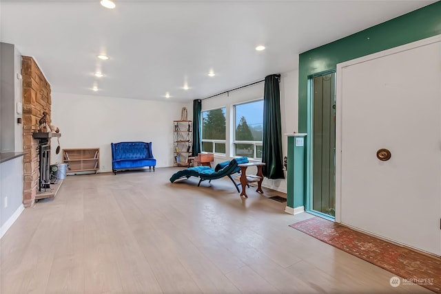 sitting room featuring a fireplace and light hardwood / wood-style flooring