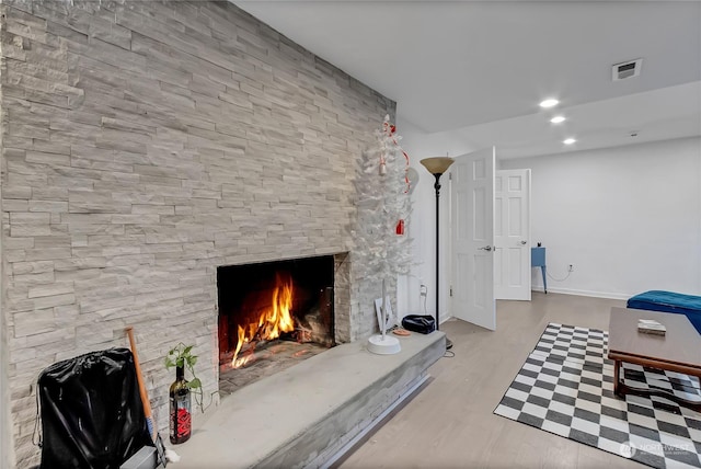 unfurnished living room featuring light hardwood / wood-style flooring and a stone fireplace