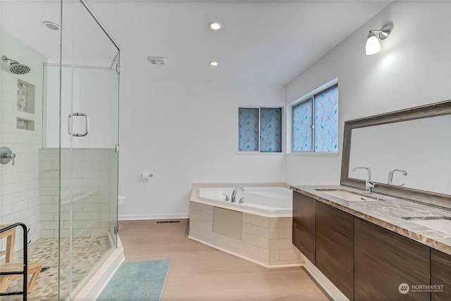 bathroom with hardwood / wood-style flooring, vanity, and separate shower and tub