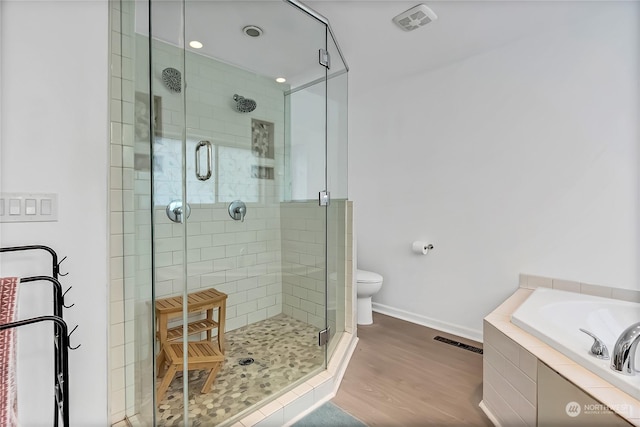 bathroom featuring plus walk in shower, hardwood / wood-style floors, and toilet