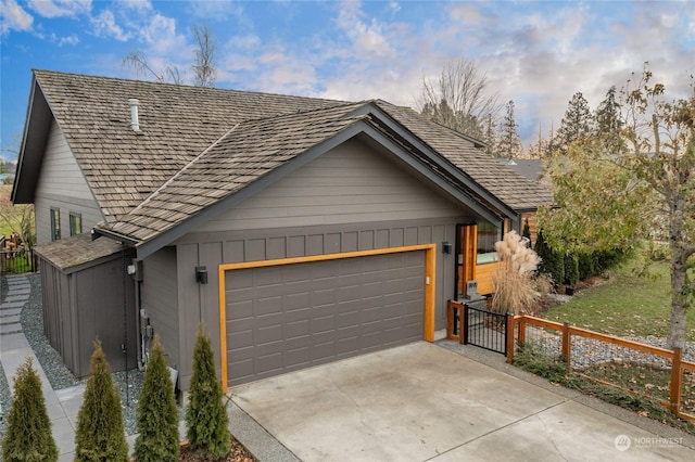 view of front of house with board and batten siding, fence, driveway, and an attached garage