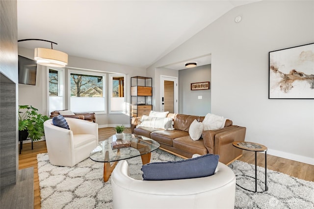 living room featuring lofted ceiling, wood finished floors, and baseboards