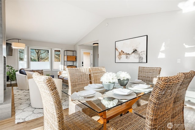 dining room with lofted ceiling and light wood-style flooring