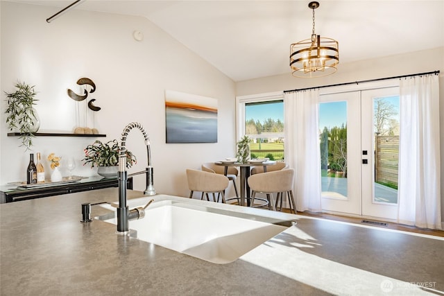 interior space featuring lofted ceiling, french doors, visible vents, and an inviting chandelier