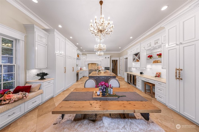 interior space with ornamental molding, a notable chandelier, and light tile patterned floors