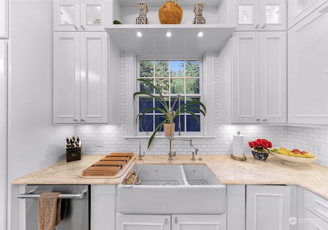 kitchen with dishwasher, white cabinetry, backsplash, and light stone counters