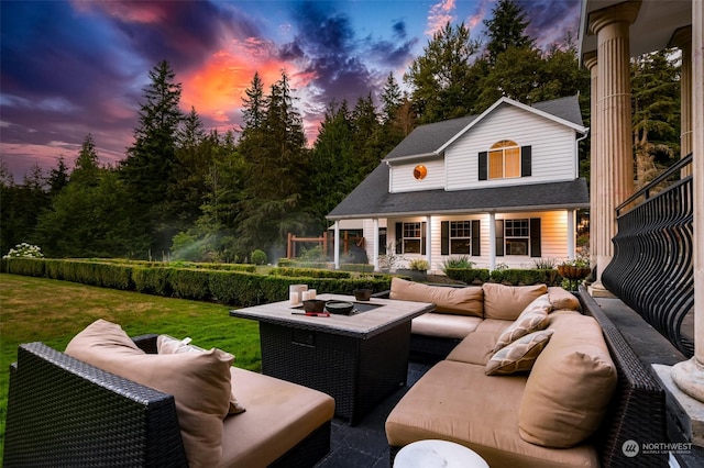 patio terrace at dusk with a lawn, an outbuilding, and an outdoor hangout area