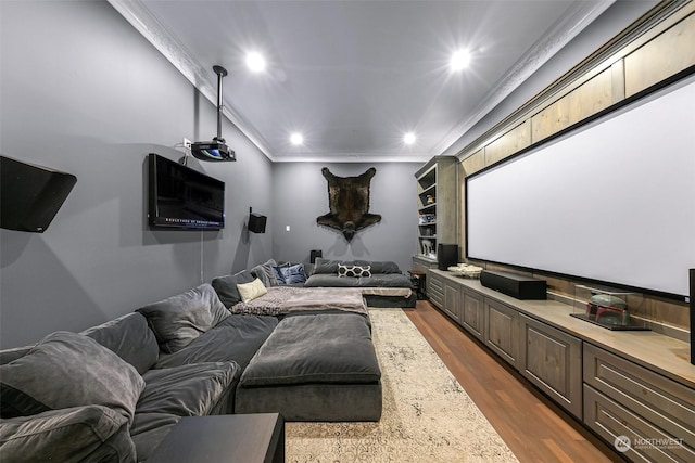 cinema room with ornamental molding and dark wood-type flooring