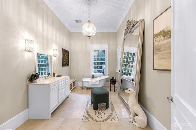 bathroom with a washtub, tile patterned flooring, crown molding, and vanity