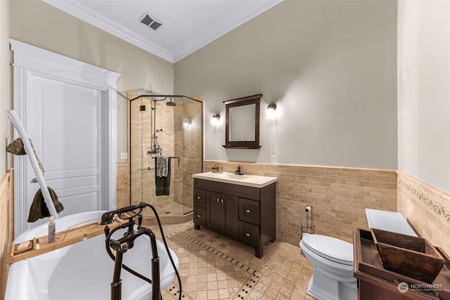 bathroom featuring toilet, crown molding, vanity, tile walls, and an enclosed shower