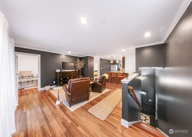 living room featuring light hardwood / wood-style flooring and crown molding